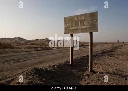 Un segno su un deserto di strada sterrata in Xinjiang, Cina Foto Stock