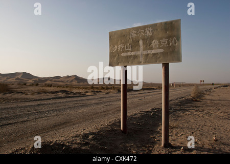 Un segno su un deserto di strada sterrata in Xinjiang, Cina Foto Stock