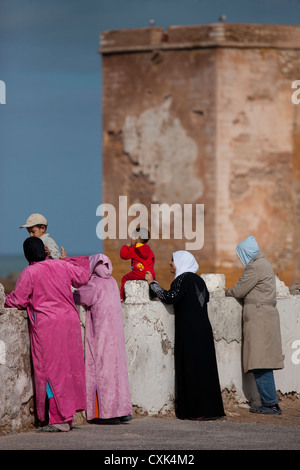 La gente del posto guardando vista dalla parete della città di Essaouira, Marocco Foto Stock