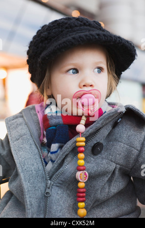 Ritratto di bambina con succhietto indossando Cothes invernale Foto Stock