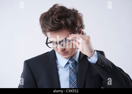 Ritratto di giovane imprenditore guardando verso il basso e indossando occhiali da vista Foto Stock