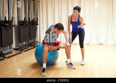Un uomo sta lavorando fuori con una femmina di personal trainer. Foto Stock
