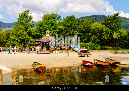 I turisti in coda il brillante sole di mezzogiorno in una bella spiaggia noleggio barche chalet a riga o vela su New Scenic 5 posti tranquilli Coniston Water Foto Stock