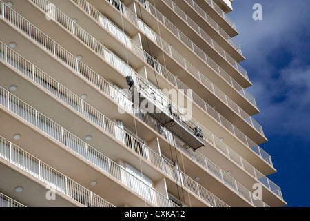 La manutenzione e la pulizia di equipaggio sulla piattaforma di sollevamento su appartamenti sviluppi sul fronte spiaggia spiaggia di Fort Lauderdale Florida usa Foto Stock