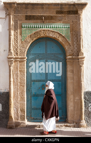 Moroccon donna oltrepassando il Blue Door, Essaouira, Marocco Foto Stock