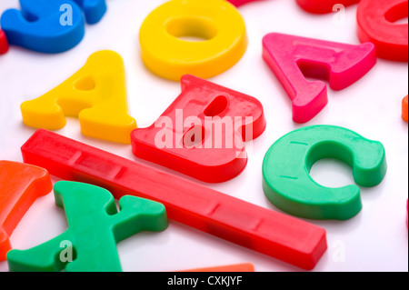 Colorate lettere di plastica su uno sfondo bianco - lettere alfabeto Foto Stock