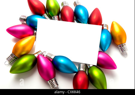 Un fustellato notecard circondato da decorazioni natalizie o baubles su uno sfondo bianco, aggiungi copia o la grafica Foto Stock