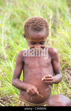 Giovane ragazzo in un campo, Nadzab village, Lae, provincia di Papua Nuova Guinea Foto Stock