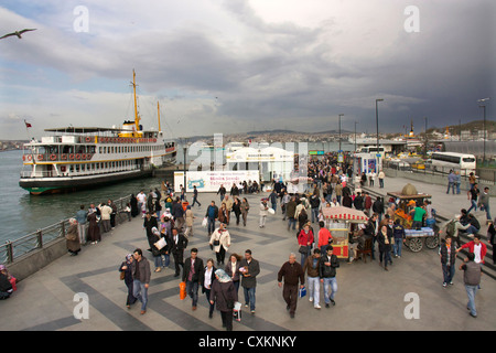 La gente sulla banchina e traghetti, Eminoenue district, Istanbul, Turchia, Europa Foto Stock