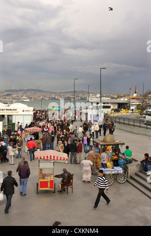 La gente sulla banchina e traghetti, Eminoenue district, Istanbul, Turchia, Europa Foto Stock