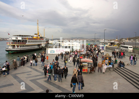 La gente sulla banchina e traghetti, Eminoenue district, Istanbul, Turchia, Europa Foto Stock