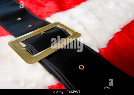 Un babbo natale in costume con sfondo rosso tuta peloso e una cintura nera, il Natale o il tema vacanze Foto Stock