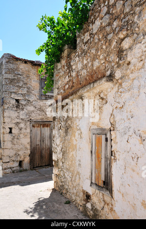 Case di pietra in una vecchia strada di Colle borgo agricolo di Kroustas, vicino a Agios Nikolaos, Creta, Grecia Foto Stock