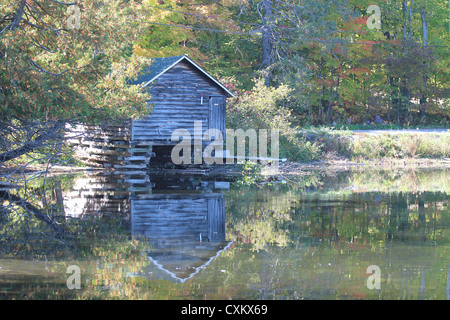 Vecchia Darsena in legno con la riflessione in acqua Foto Stock