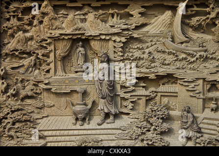 Guan Yin in legno intagliato vernice nel tempio cinese Foto Stock