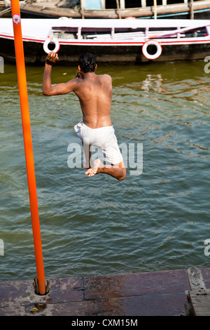 L'uomo saltando nel fiume Gange a Varanasi Foto Stock