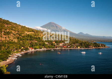Guardando attraverso Jemeluk bay ad Amed con Gunung Agung vulcano sullo sfondo, Bali Orientale, Indonesia. Foto Stock