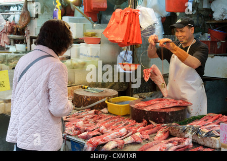 La pesatura del pesce in Bowrington Road mercato umido, Hong Kong Foto Stock