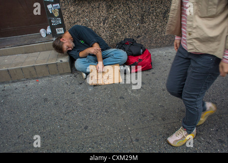 New York City, NY, STATI UNITI D'AMERICA, senzatetto uomo dorme, accattonaggio sul marciapiede, azienda Accedi, Chinatown, Manhattan Foto Stock