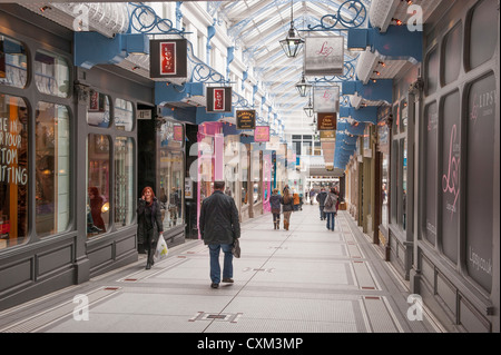 Gli amanti dello shopping a piedi nella attraente storico Queen's Arcade (file di negozi sotto l'impressionante tetto di vetro) - centro cittadino di Leeds, West Yorkshire, Inghilterra, Regno Unito. Foto Stock