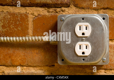 Elettrici industriali in uscita su un rosso un muro di mattoni, il concetto di potenza o la connettività ecc. Foto Stock