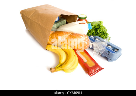 Una carta marrone borsa piena di negozi di generi alimentari su uno sfondo bianco, con pane, latte, uova, pasta, insalata e banane. con spazio di copia Foto Stock