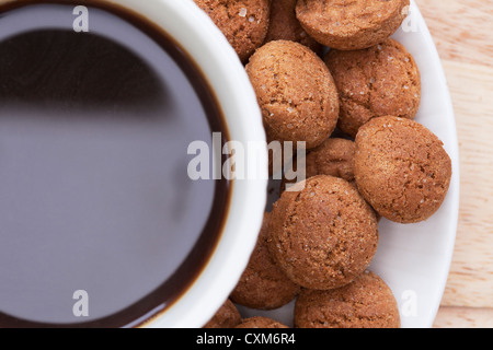 In prossimità della tazza di caffè con kruidenootjes, olandese spice cookes, attorno al bordo. Colpo da direttamente sopra Foto Stock