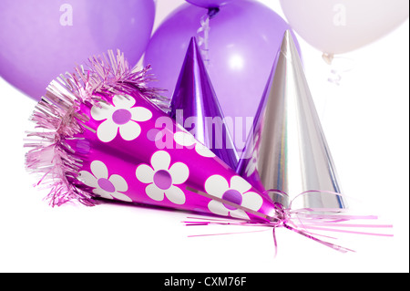 Festa di compleanno lo sfondo con il partito di cappelli e palloncini flottante su sfondo bianco Foto Stock