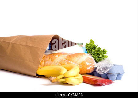 Una carta marrone borsa piena di negozi di generi alimentari su uno sfondo bianco, con pane, latte, uova, pasta, insalata e banane. con spazio di copia Foto Stock