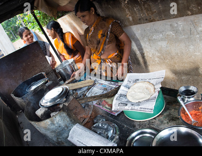 Donna indiana che dosa di cottura per la gente per strada. Andhra Pradesh, India Foto Stock