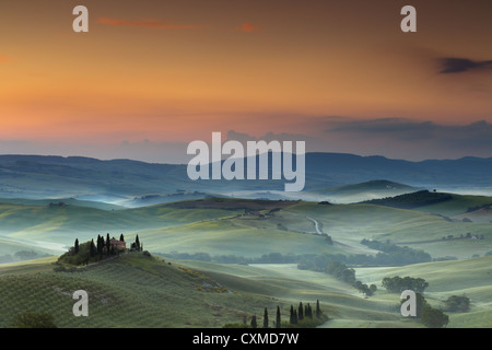 Villa Belvedere di San Quirico d'Orcia in colline toscane su un nebbioso giorno all'alba Foto Stock