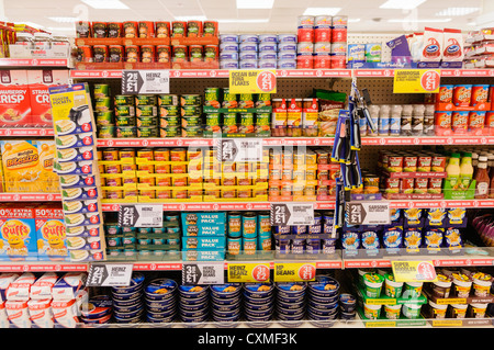 I prodotti alimentari in vendita sugli scaffali di un Poundland shop store. Foto Stock