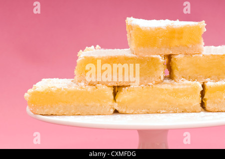 Deliziosi appena sfornato piazze di limone su una torta bianca stand Foto Stock