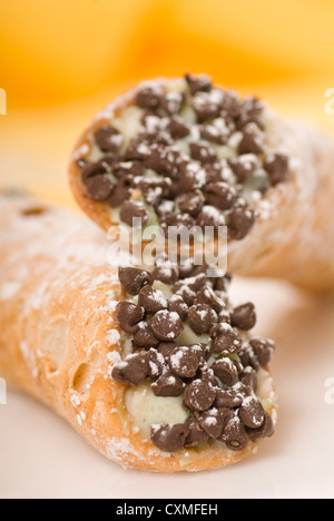 Due appena sfornato cannoli impilati gli uni sugli altri e spolverato con zucchero a velo Foto Stock