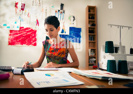 Abito ispanica maker facendo del bilancio in atelier studio Foto Stock