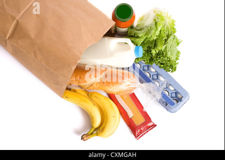 Una carta marrone borsa piena di negozi di generi alimentari su uno sfondo bianco, con pane, latte, uova, pasta, insalata e banane. con spazio di copia Foto Stock