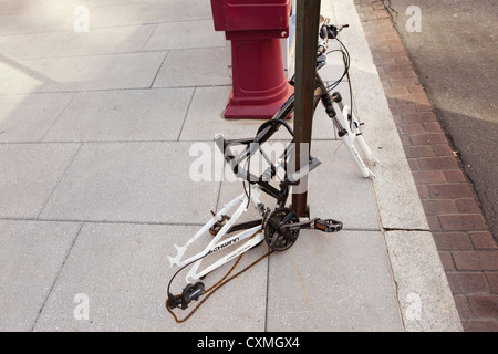 Vandalizzato bicicletta su strada segno post (vandalizzato bike frame) - USA Foto Stock