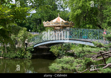 Jardin Public, Bordeaux, Gironde, Francia - giostra con ride in background Foto Stock