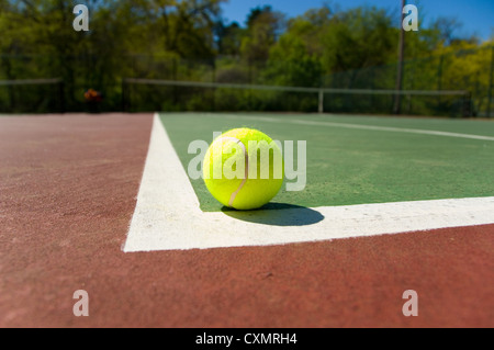 Verdolino brillante, giallo palla da tennis su dipinta di fresco corte di cemento Foto Stock