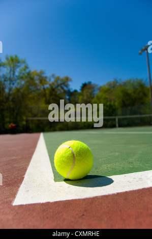 Verdolino brillante, giallo palla da tennis su dipinta di fresco corte di cemento Foto Stock