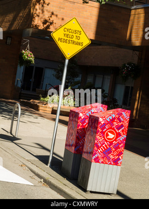 I ciclisti resa ai pedoni segno, pista ciclabile, del centro cittadino di Vancouver, Canada Foto Stock