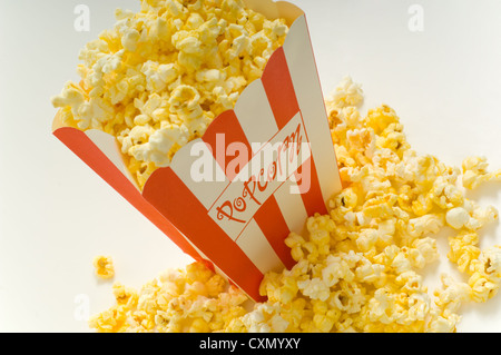 Film popcorn su sfondo bianco con strisce rosse box e fresco popcorn schioccato in su sfondo bianco Foto Stock