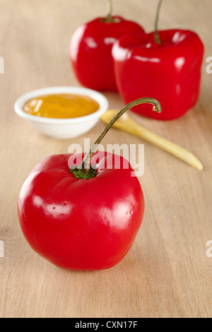 Peruviano pepe caldo chiamato rocoto con la salsa fatta fuori di esso in background (messa a fuoco selettiva, messa a fuoco sulla parte anteriore rocoto) Foto Stock