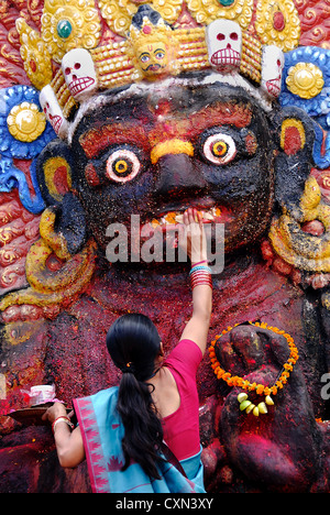 Donna che fa un'offerta alla madre indù Dea Kali, Kathmandu, Nepal Foto Stock