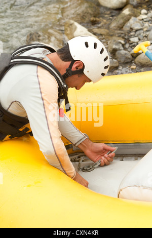 Rafting manutenzione barca pilota di preparare la barca per la prossima avventura Foto Stock