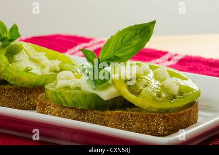 Cimelio di pomodori tagliati a fette con basilico e formaggio per fare la bruschetta Foto Stock