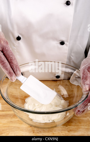 Lo chef femmina di fresco con la maionese fatta in una ciotola di vetro Foto Stock