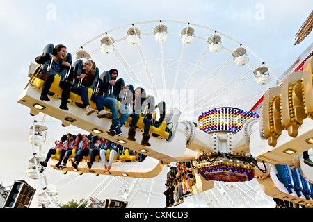 Persone a cavallo sulla sommità Buzz fairground ride a Nottingham storico Fiera d'oca. Foto Stock