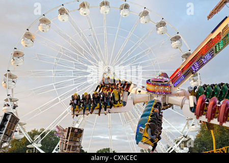 Persone a cavallo sulla sommità Buzz fairground ride a Nottingham storico Fiera d'oca. Foto Stock