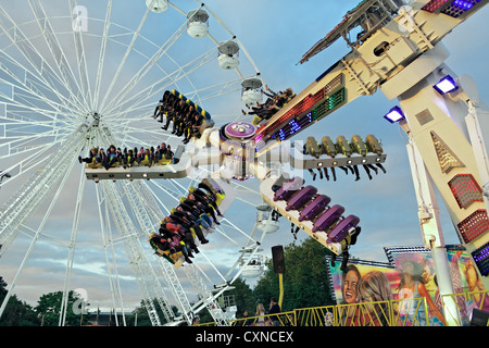 Persone a cavallo sulla sommità Buzz fairground ride a Nottingham storico Fiera d'oca. Foto Stock